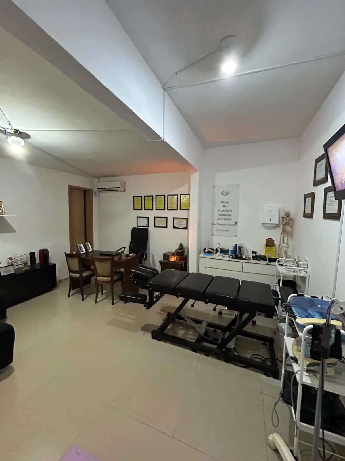 Sala de atendimento fisioterapêutico com maca e área de avaliação