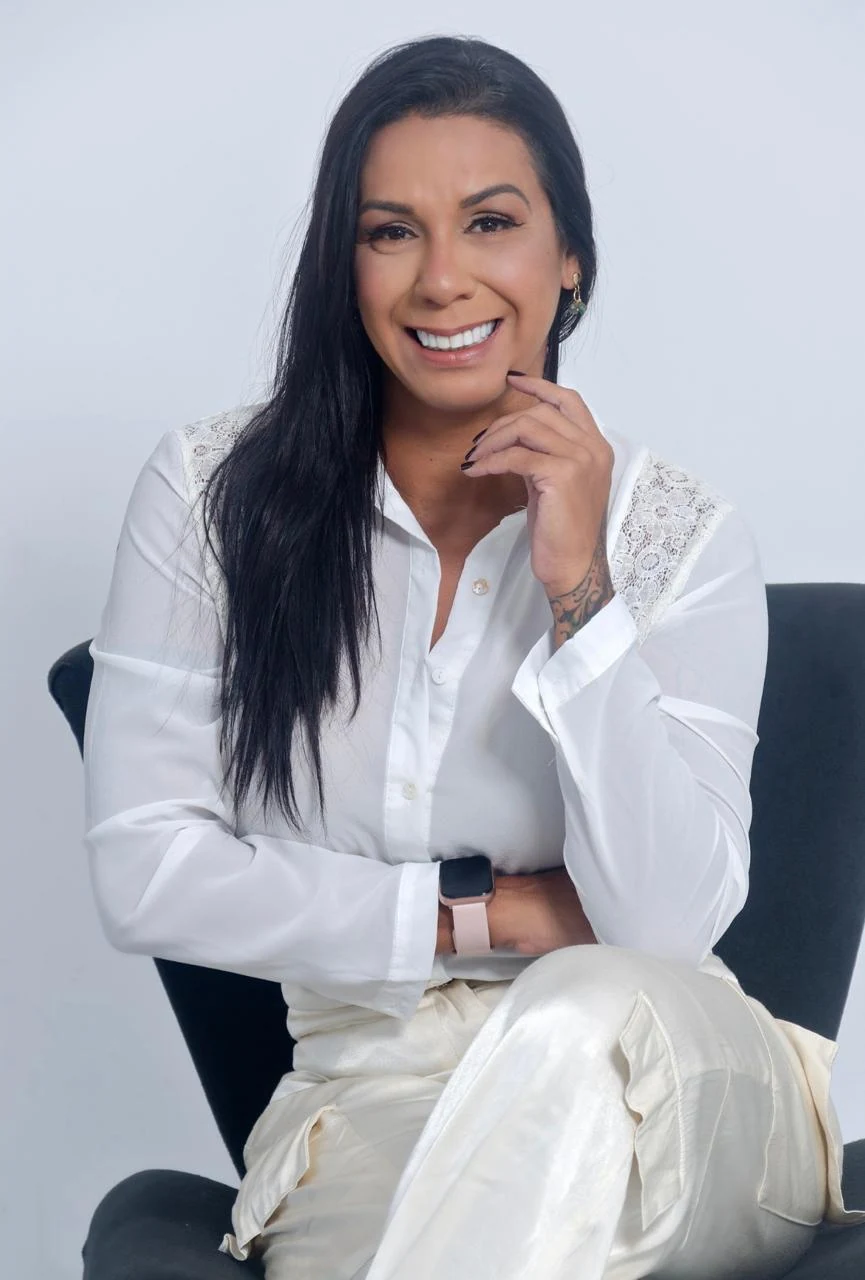 Dra. Monique Moraes, fisioterapeuta, sorrindo no retrato profissional